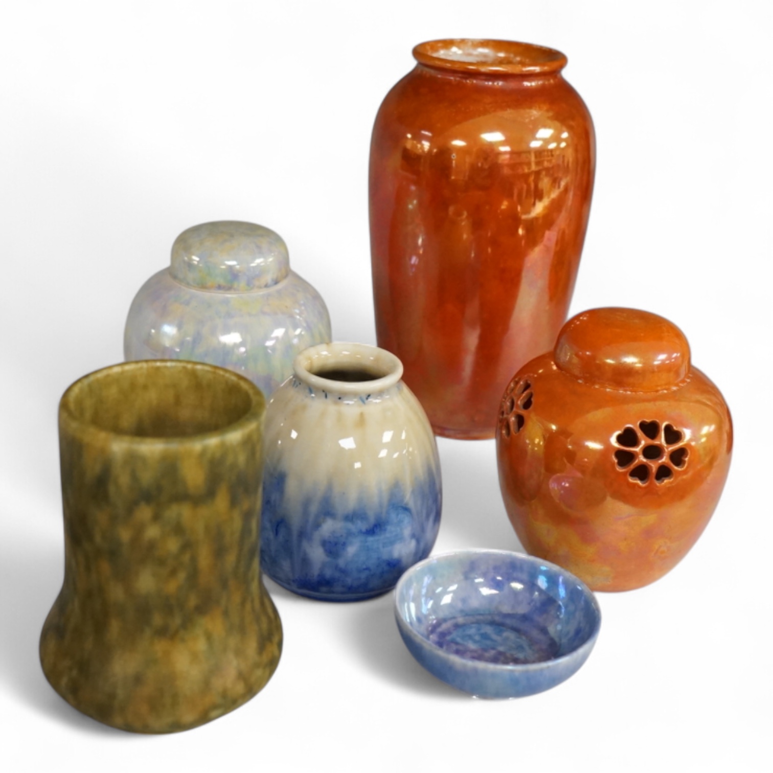 A group of six Ruskin pottery items, comprising an orange lustre vase, similar jar and cover, another lustre jar and cover, vase and small bowl together with an unglazed green vase, tallest 15.5cm
